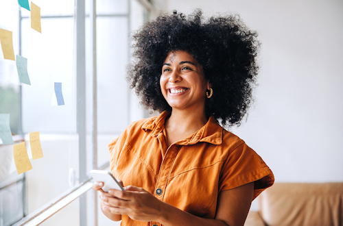 A woman smiling and holding a phone