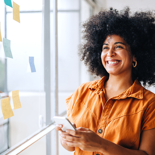 A woman smiling and holding a phone