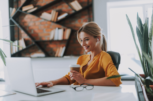 Woman sitting and smiling working at her desk