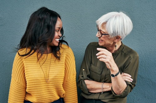 Two women from different generations standing next to each other and laughing together