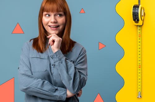 Redheaded woman standing next to a measuring tape, symbolising measuring ROI vs ROE