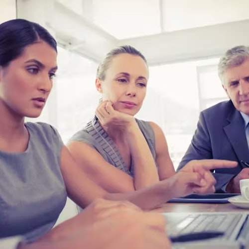 A group of employees looking at a laptop screen, representing social media awareness