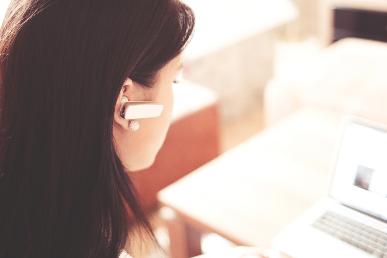 Woman wearing a headset typing on a computer