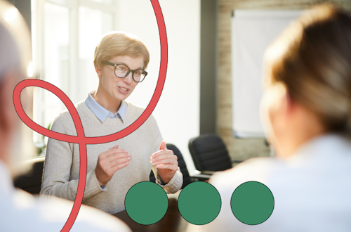 Woman wearing black glasses speaking in a meeting