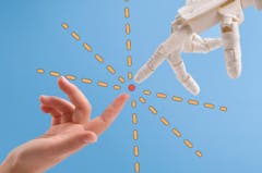Robot hand and human hand reaching out with index fingers to touch each other in the middle