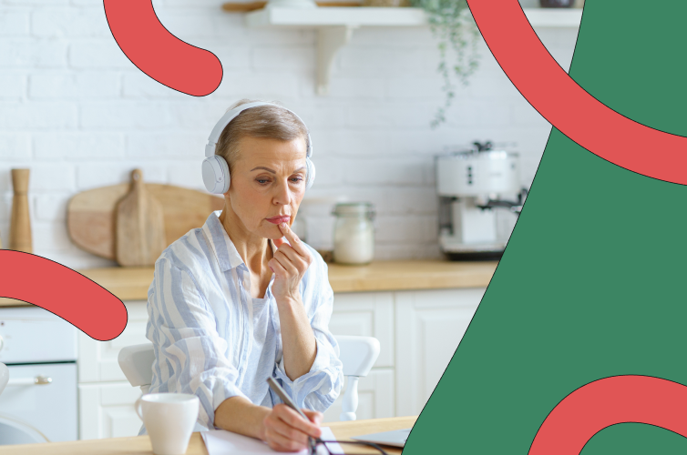 Woman sitting at a desk with headphones in looking thoughtful