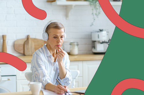 Woman sitting at a desk with headphones in looking thoughtful