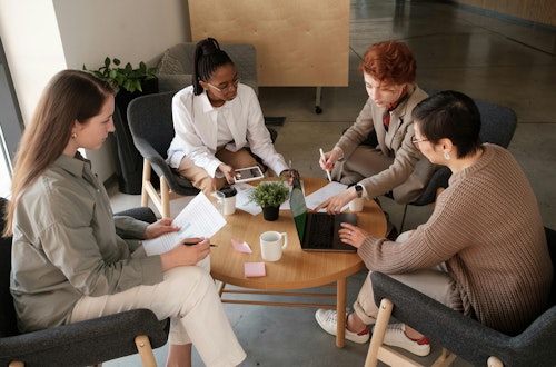 Group of employees sitting around a table at work, representing engagement