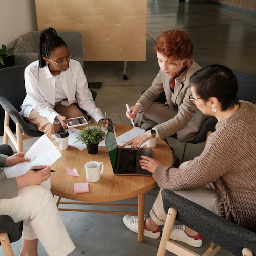 Group of employees sitting around a table at work, representing engagement