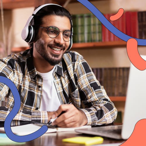 Man wearing headphones smiling at laptop