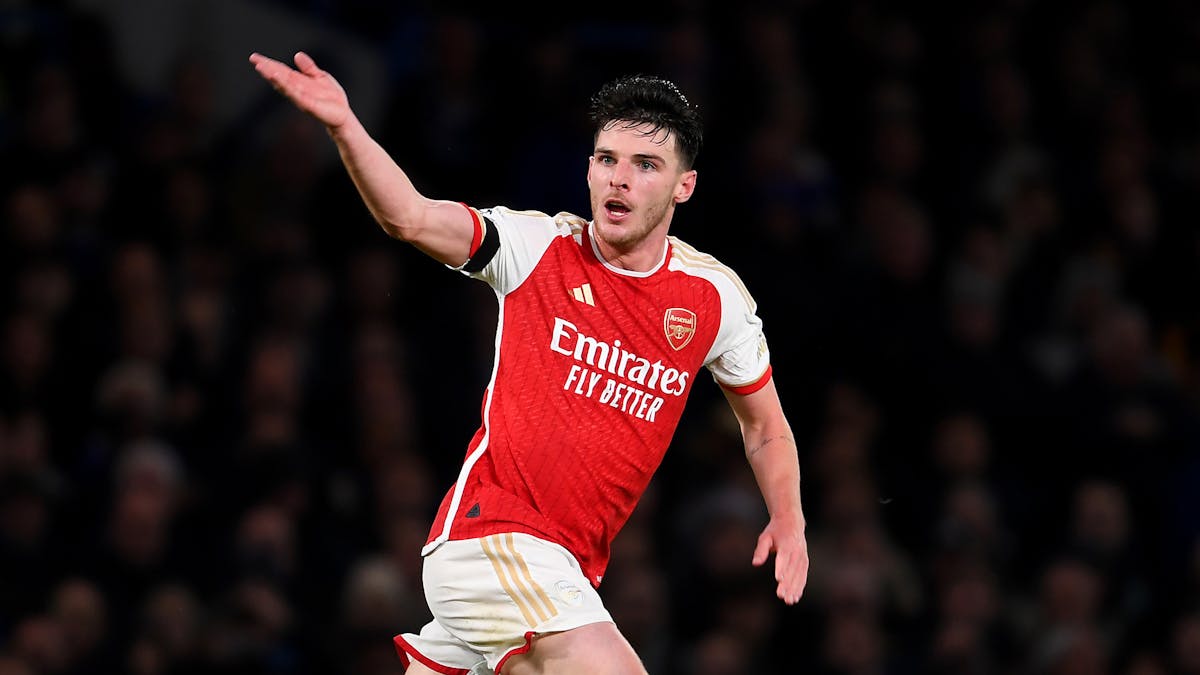 Declan Rice celebrates passionately after scoring a goal for Arsenal, gesturing toward the crowd at the Emirates Stadium