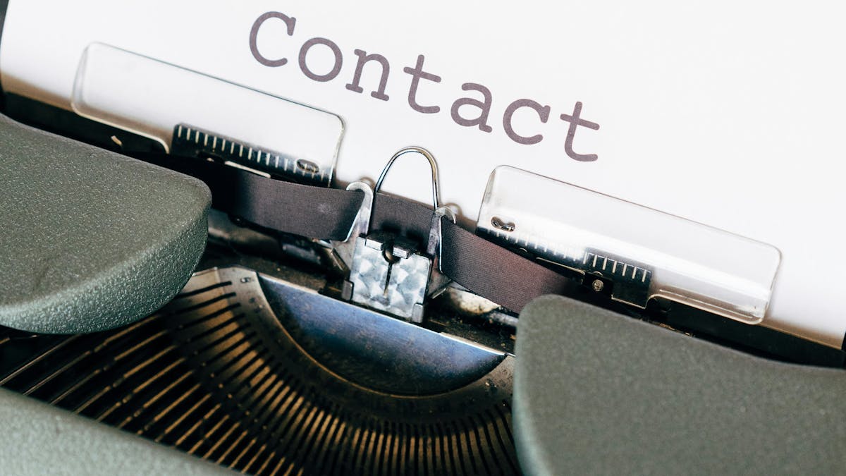 Manual Typewriter printing the word "contact"