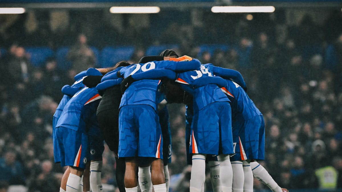 Chelsea players in home jerseh holding a final team-talk just before a match begins