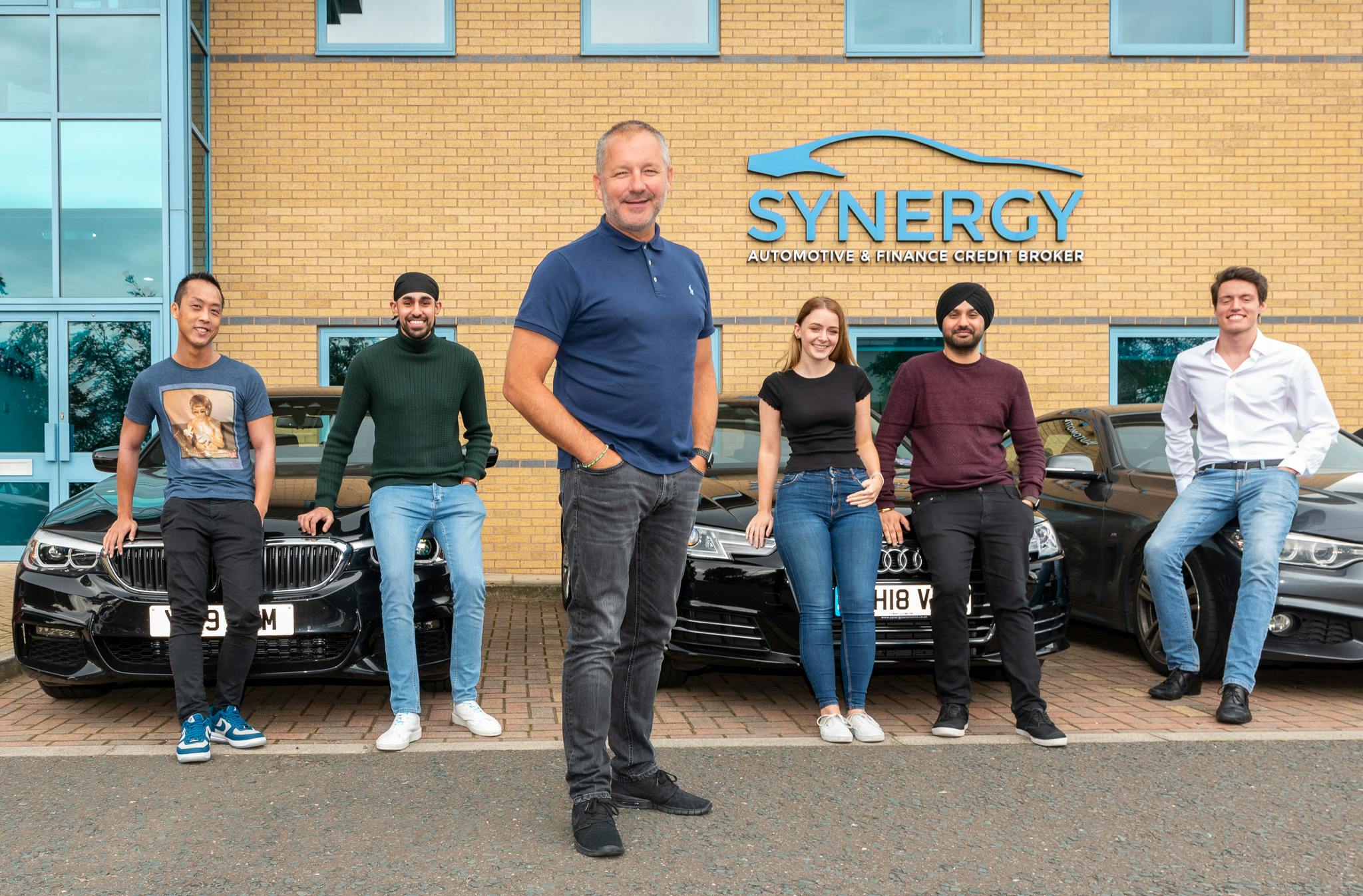 Six members of the Synergy Car Leasing team standing outside their offices.