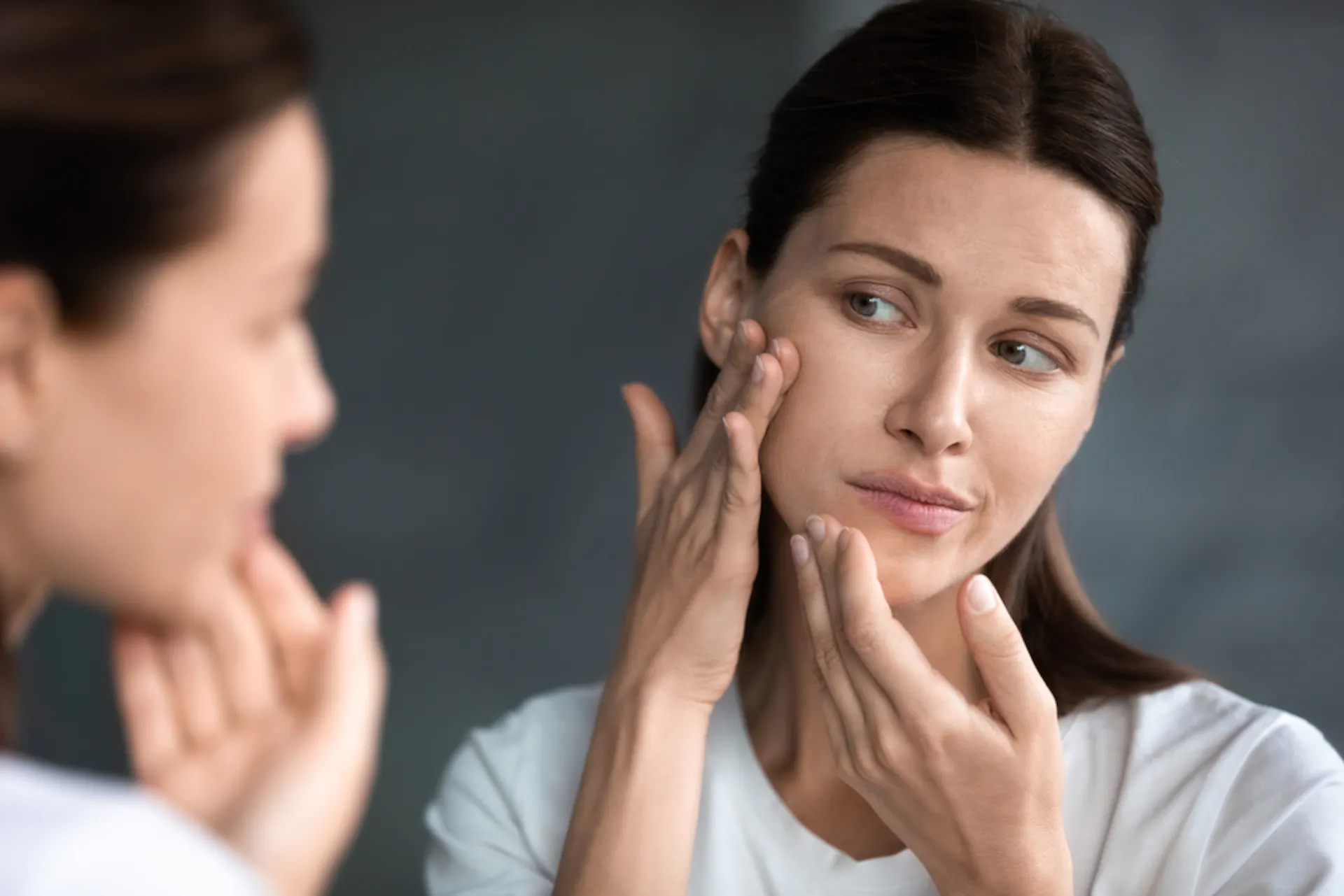A woman checking her face for rashes 