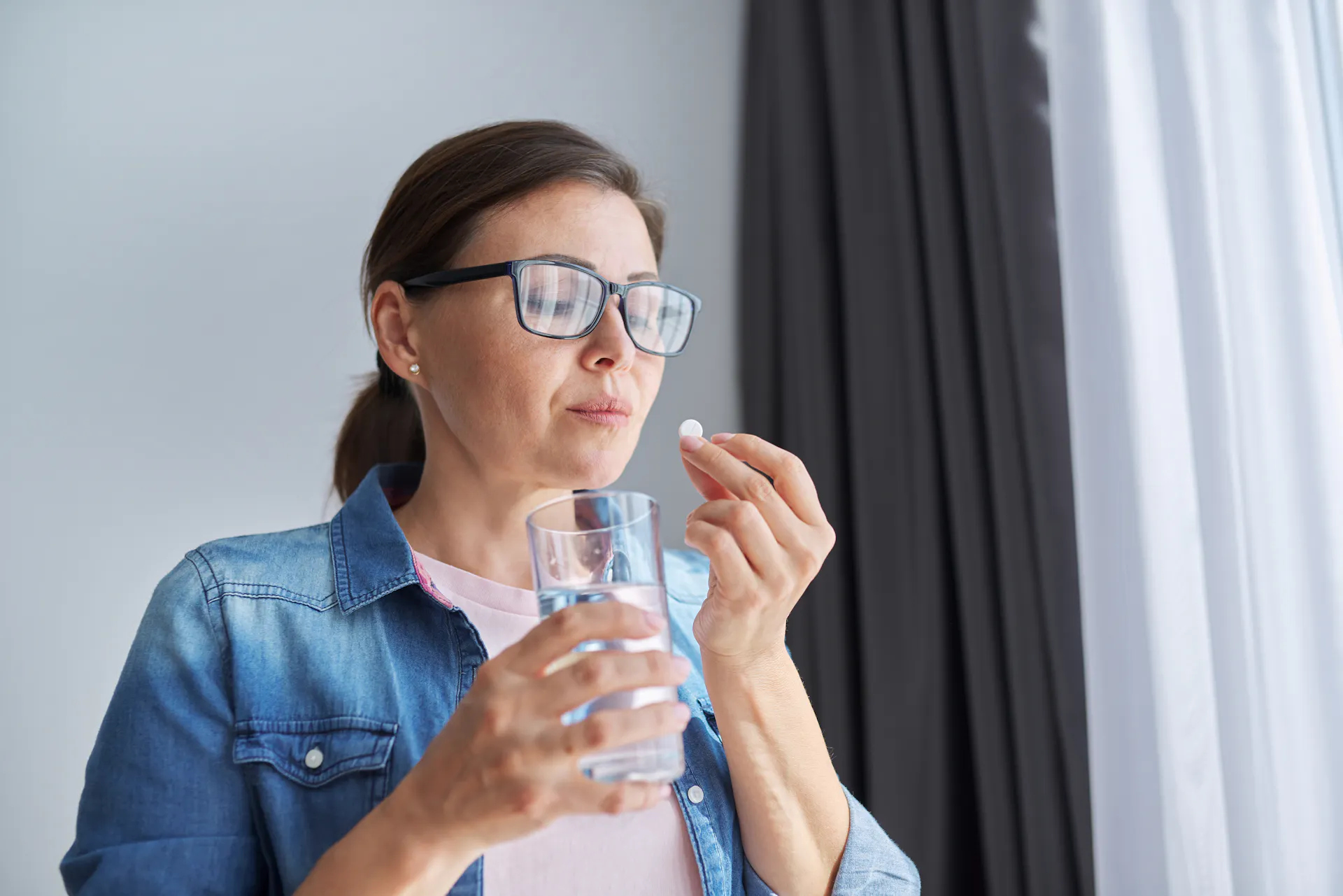 woman taking antibiotics with water