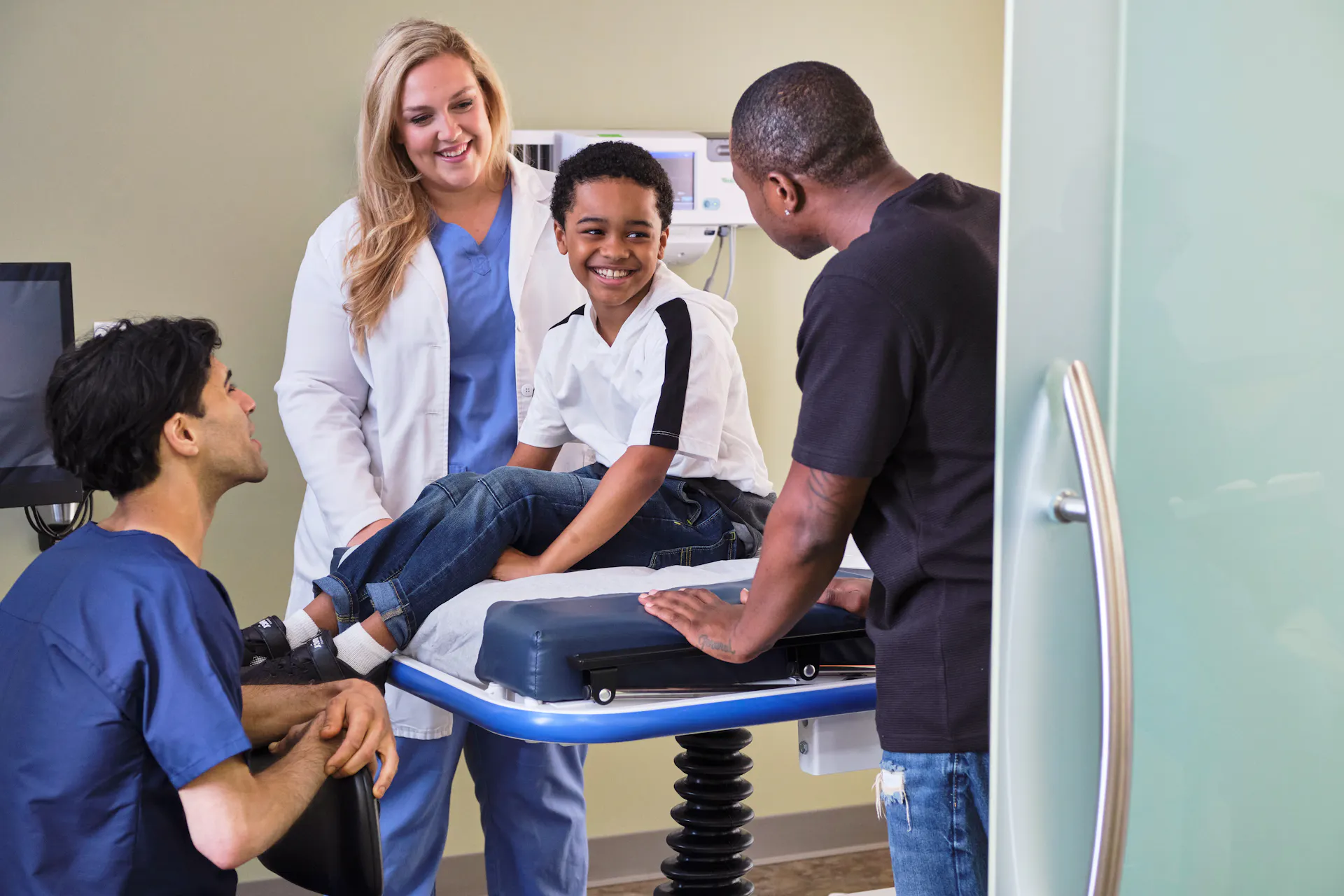 A provider and nurse speaking to a father and son at a clinic