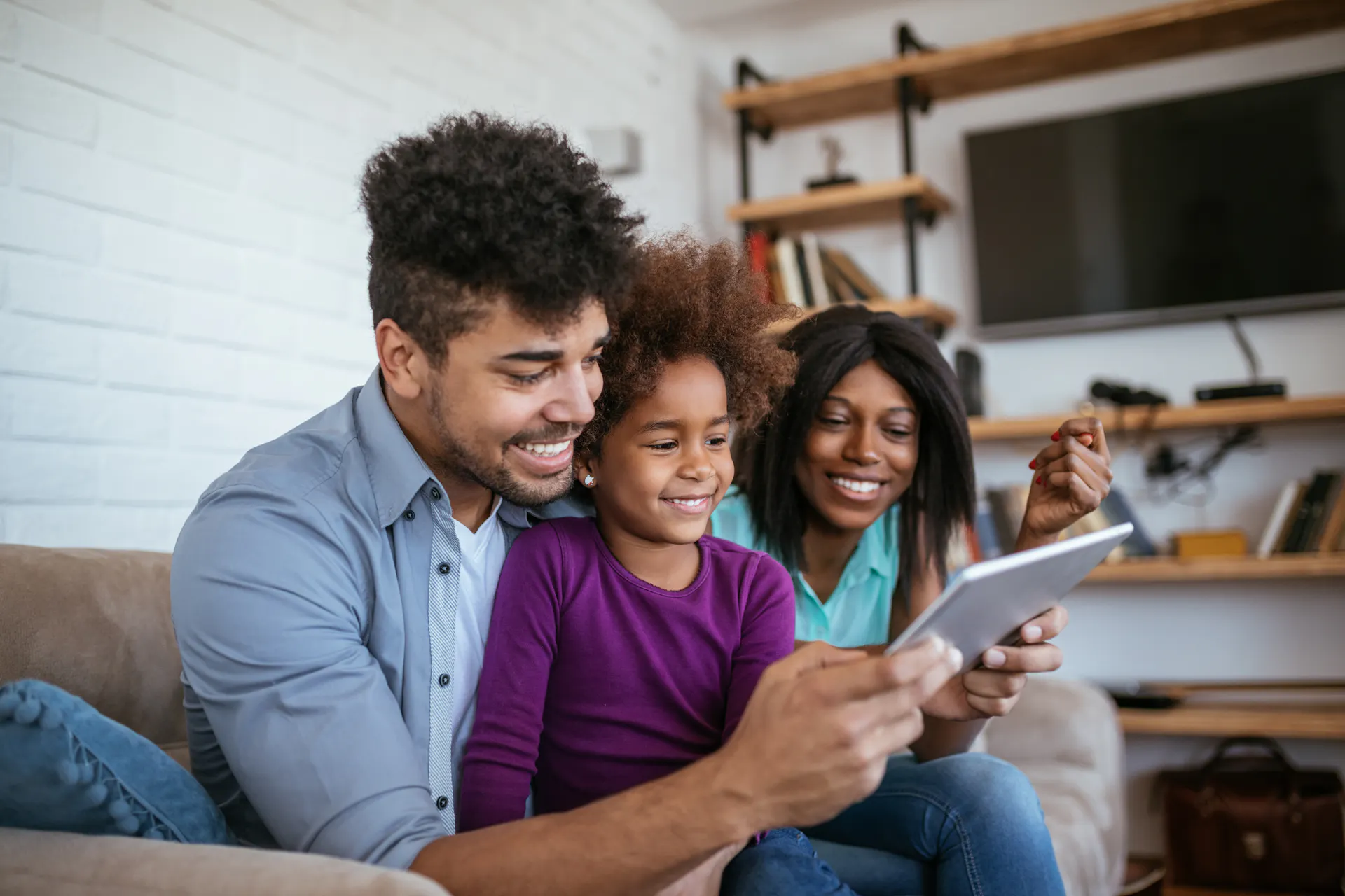 A family using a tablet at home to speak to a provider