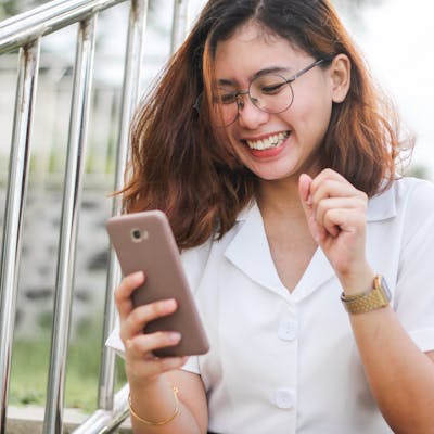 Young woman looking at phone and smiling