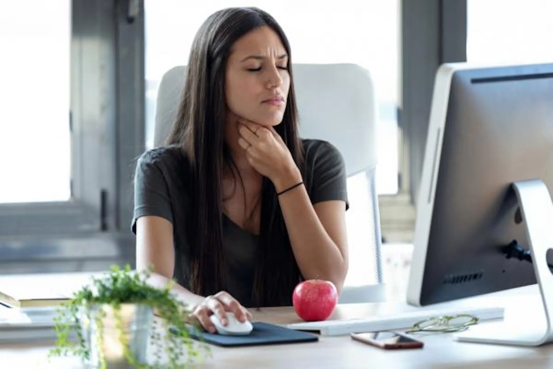An uncomfortable woman at work feeling her throat