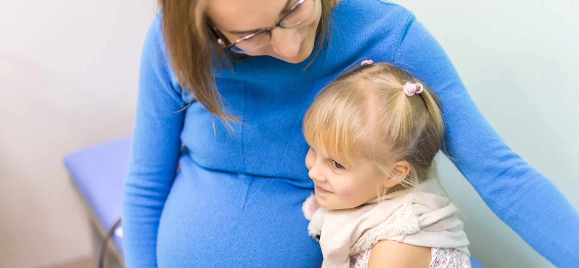 A pregnant women with her child