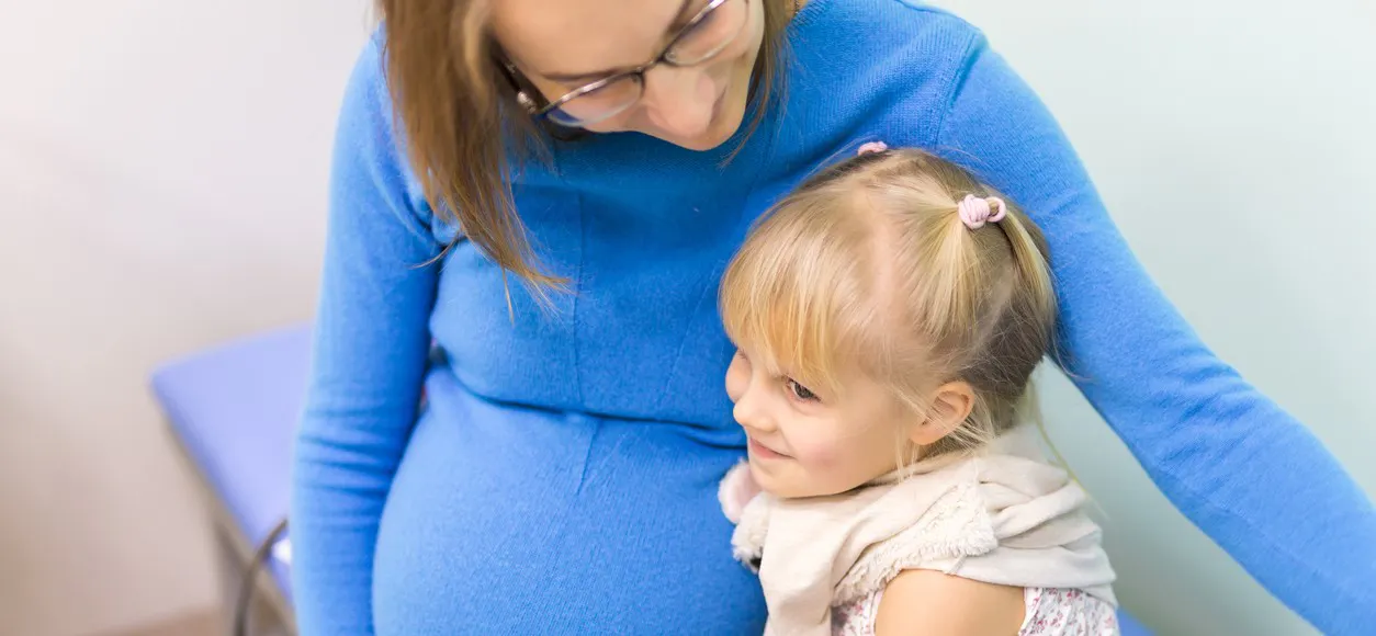 A pregnant women with her child