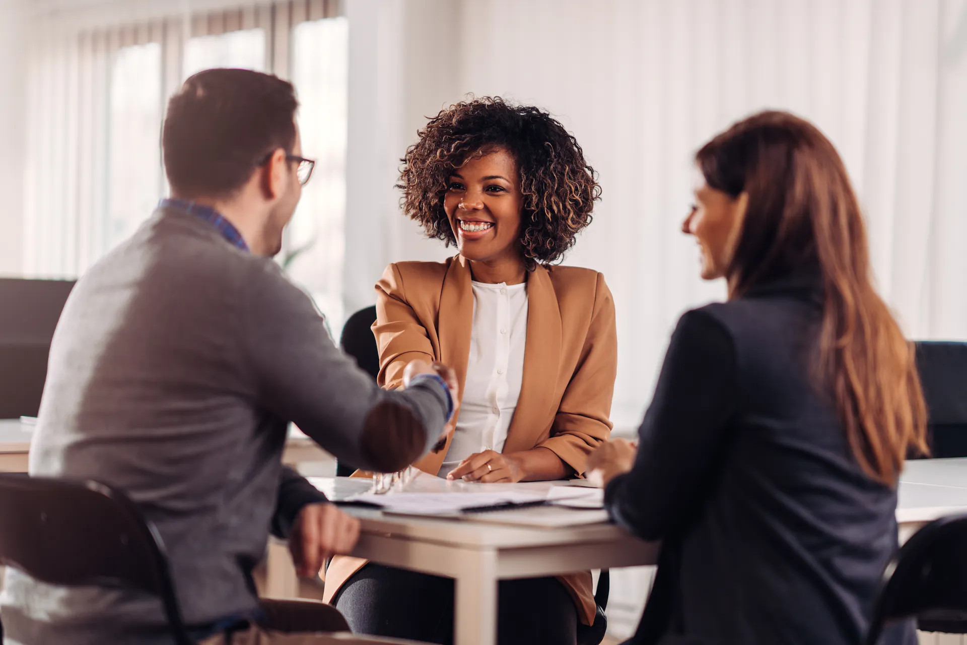 Team members shaking hands at a table