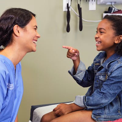 Provider and a young girl laughing together