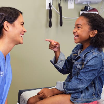 Provider and a young girl laughing together