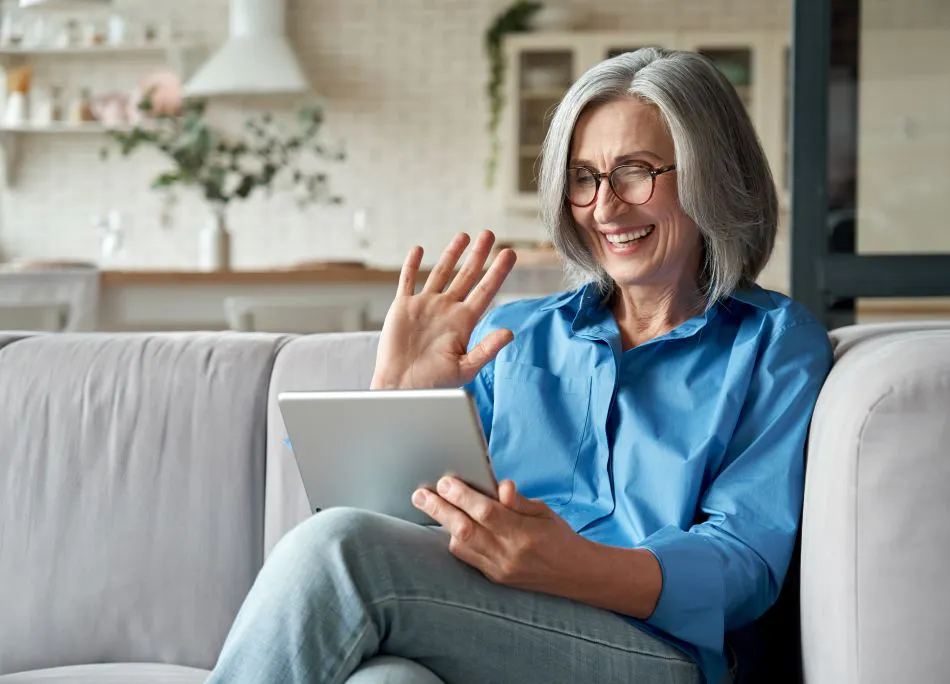 Happy 60s older mature middle aged adult woman having a telehealth appointment.