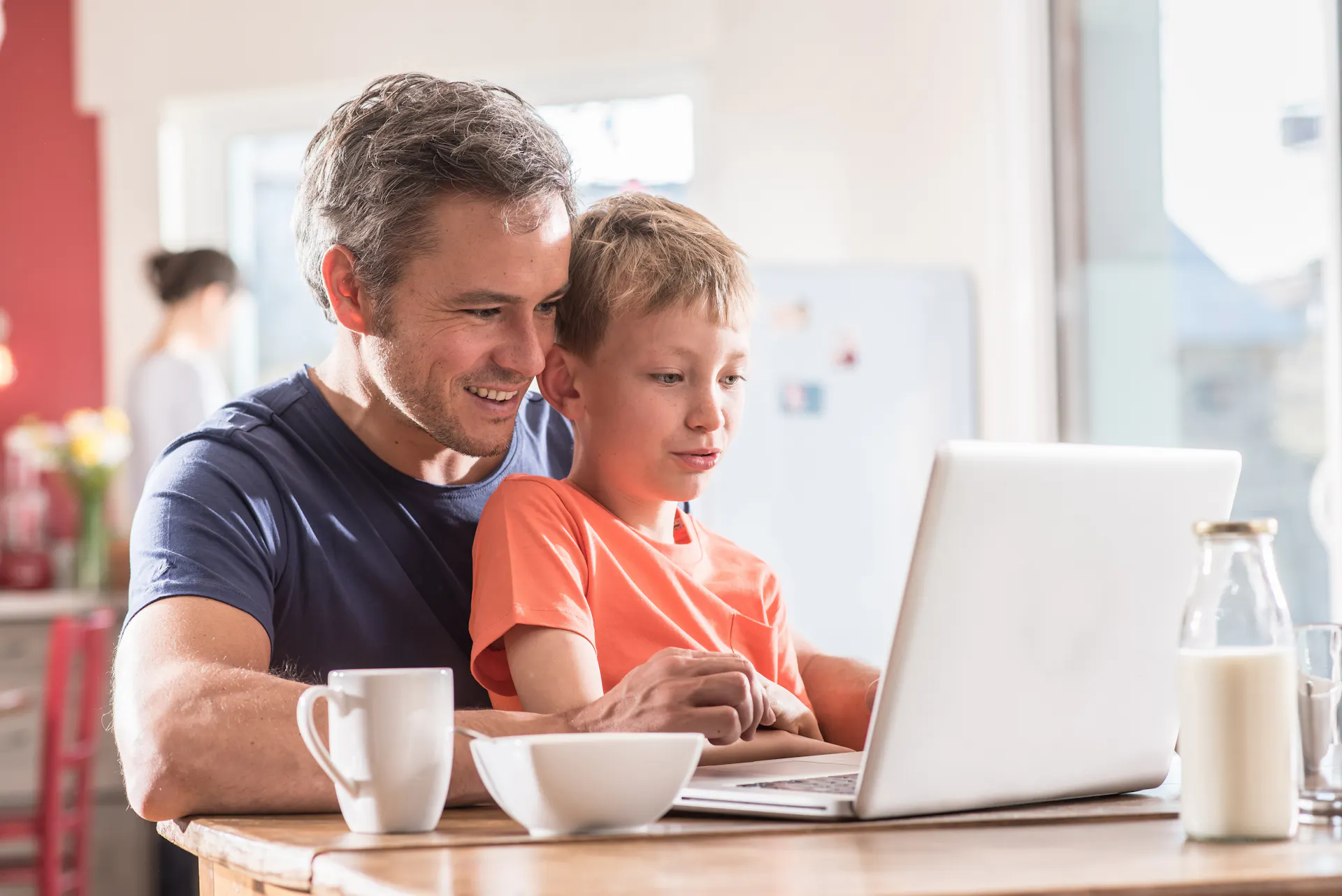A father an son using a laptop at home