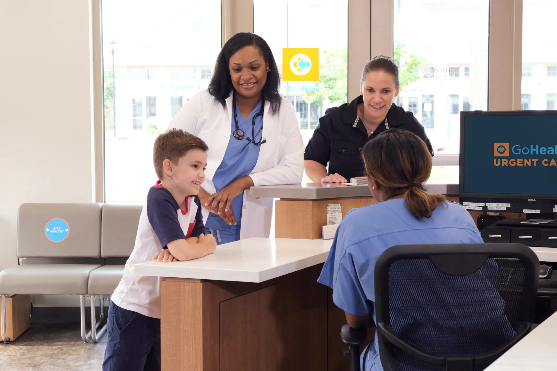 A mother and son checking in to a GoHealth Urgent Care center