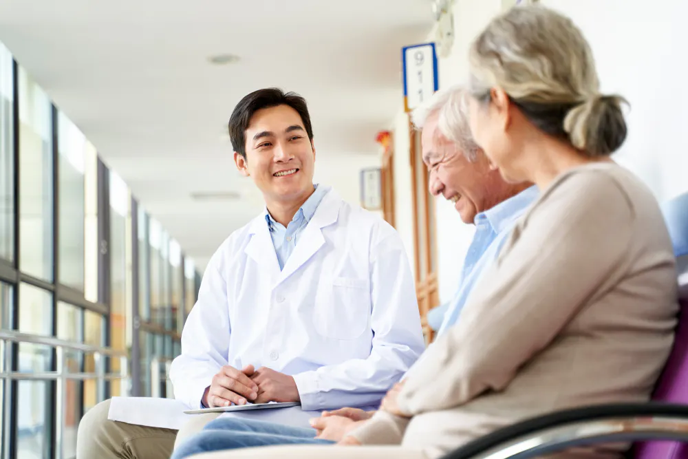 A friendly young doctor talking to an older couple