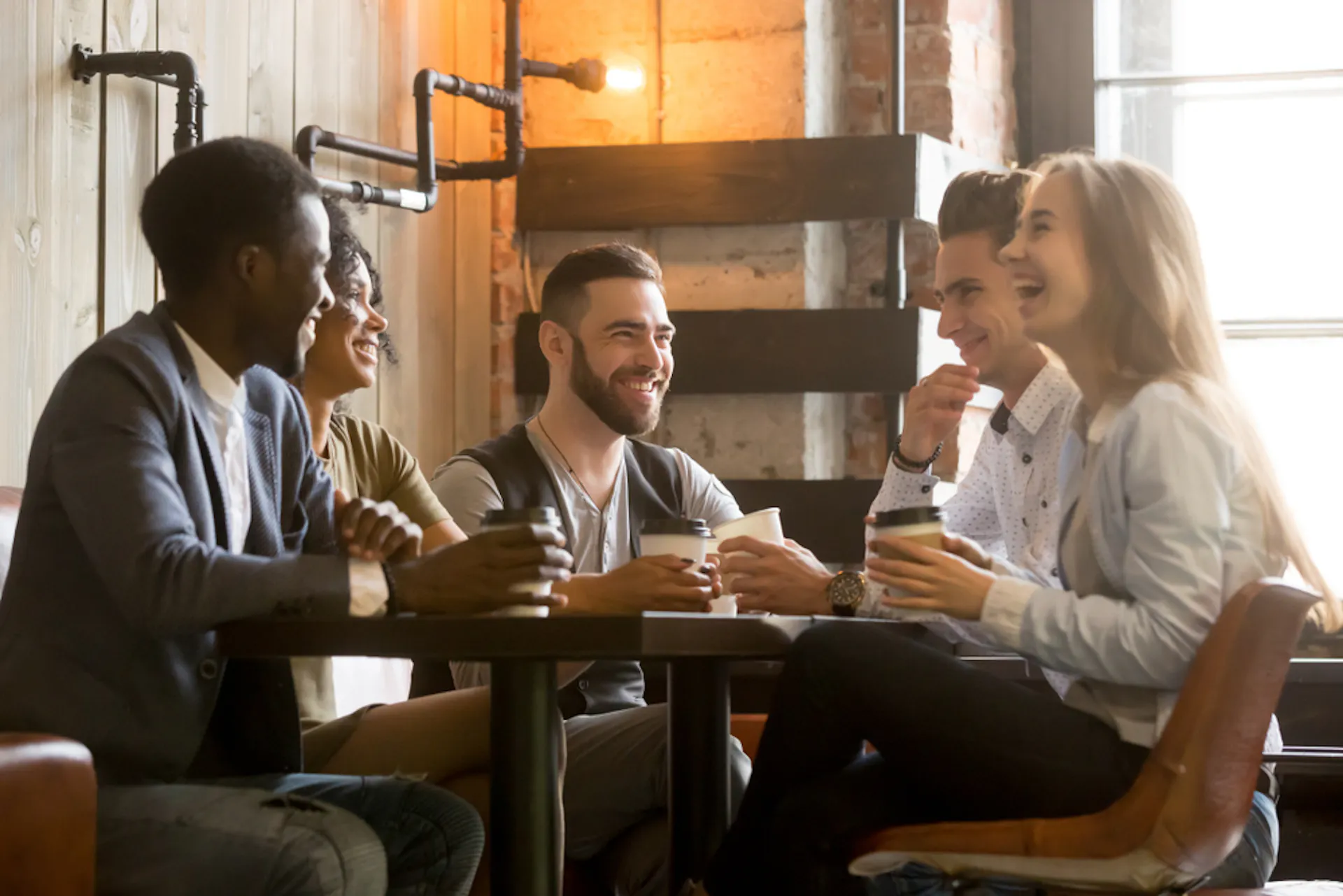 Friends sitting at a table talking and laughing