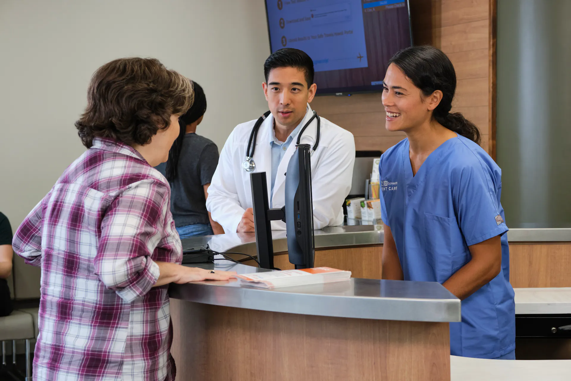 Patient speaking to physician at front desk
