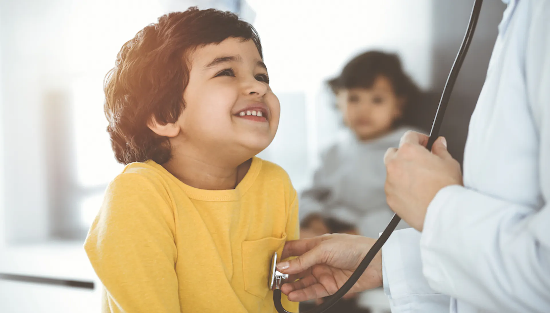 A doctor checking a child's heartbeat