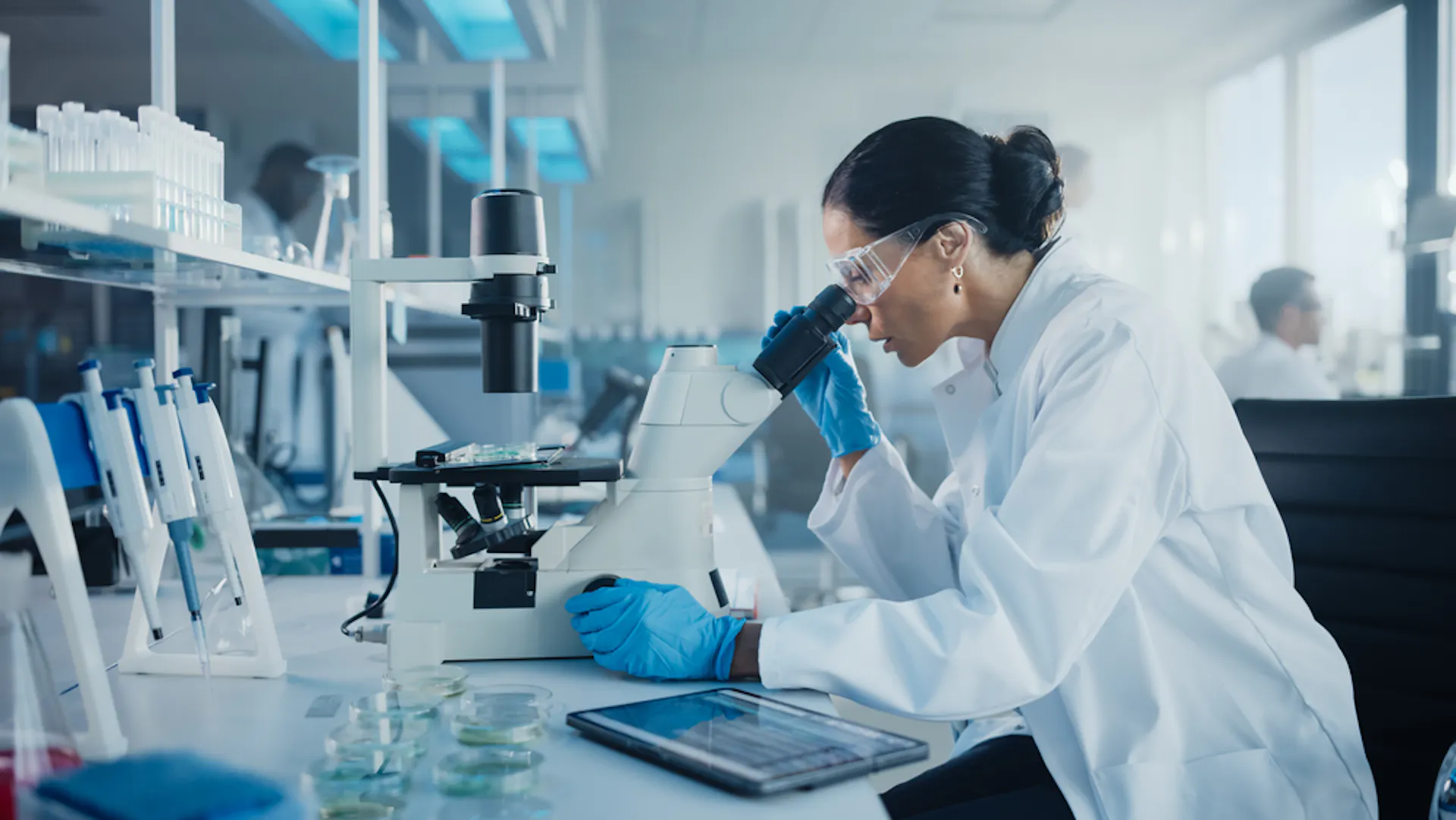 Lab tech looking into microscope