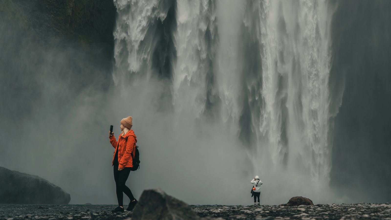 People walking around at the bottom of Skógafoss.