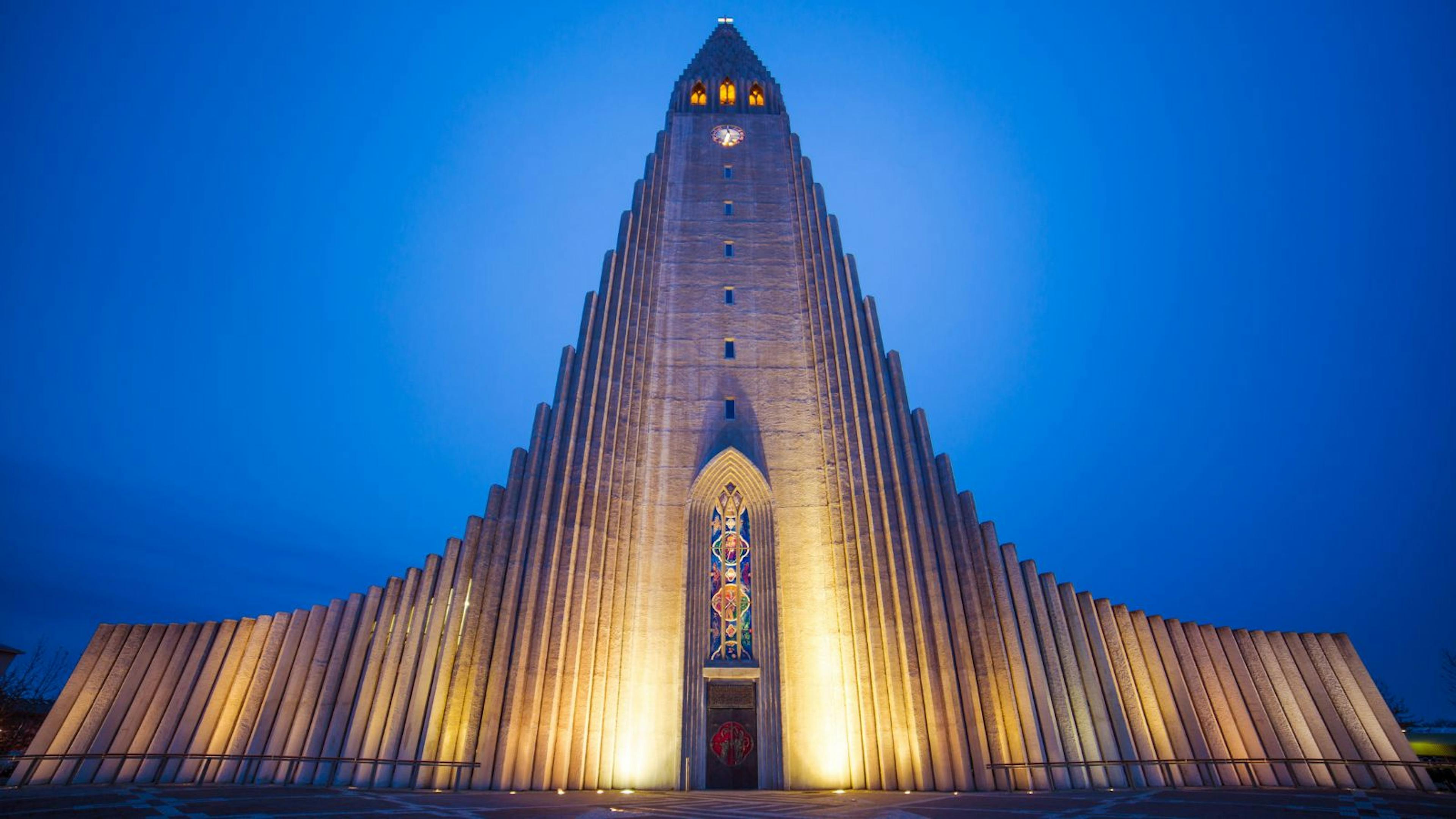 Hallgrímskirkja lit up against a cloudy sky.