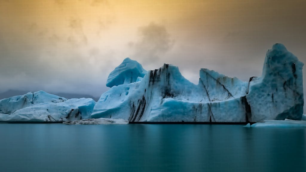 Black and blue icebergs at Jökulsárlón Glacier Lagoon against a dark sky.