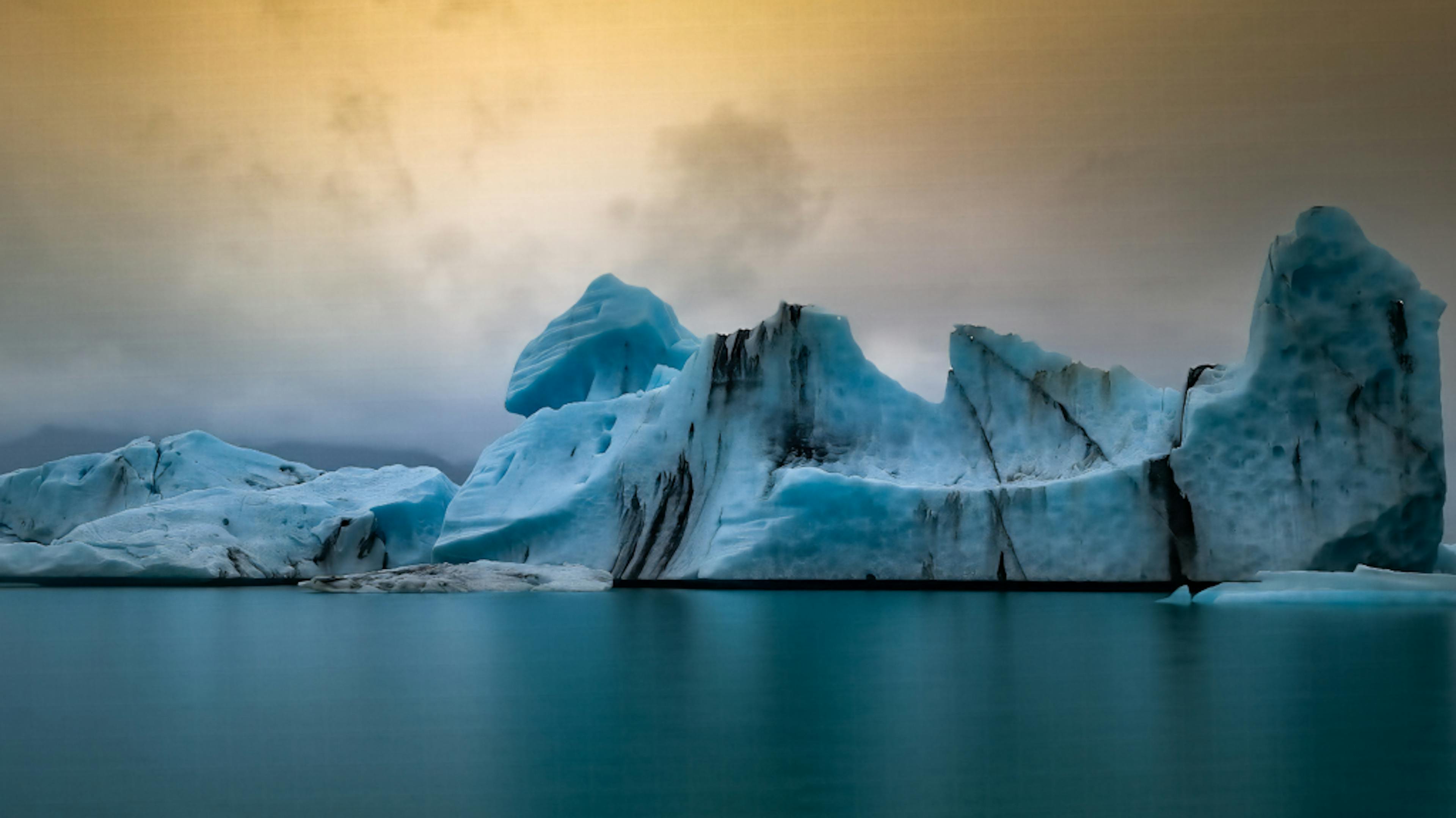 Black and blue icebergs at Jökulsárlón Glacier Lagoon against a dark sky.