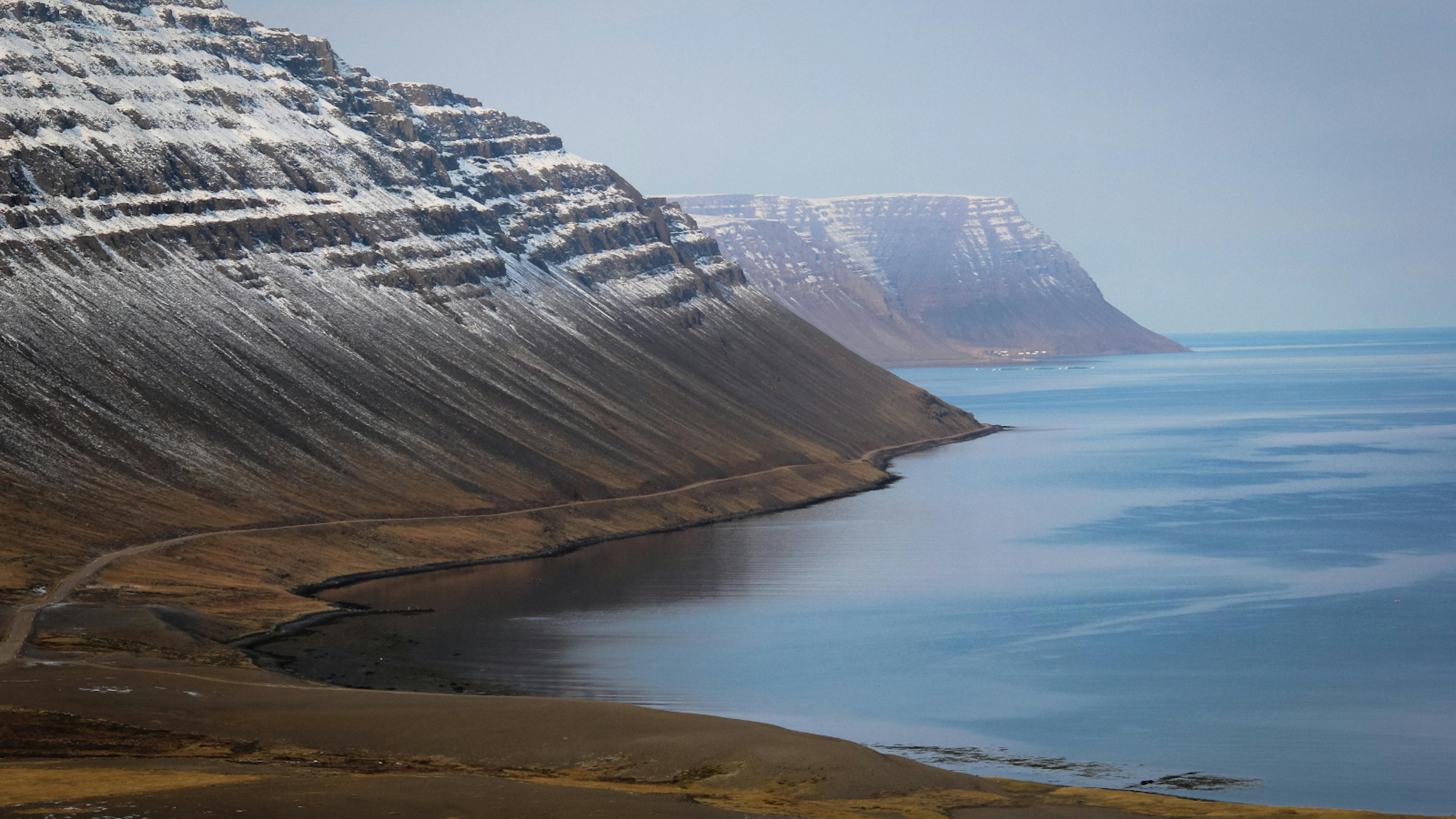 Snowcapped mountains alongside a fjord in the Westfjords region of Iceland.