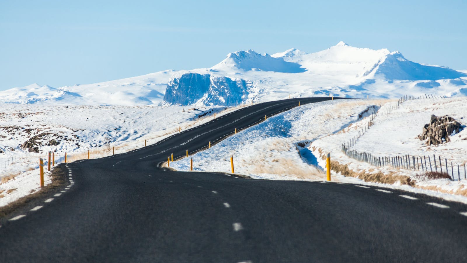 Winding road surrounded by snow in Iceland during winter