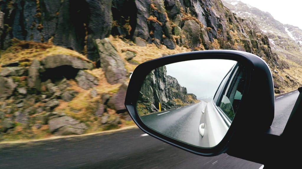 Wing mirror view at mossy Icelandic countryside.