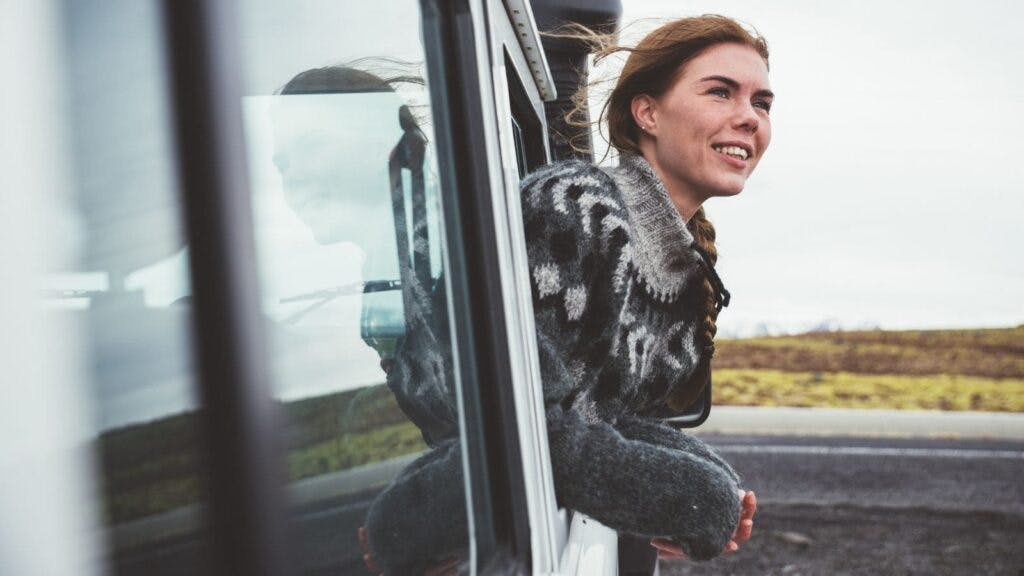 A woman leaning out of a car in Iceland.