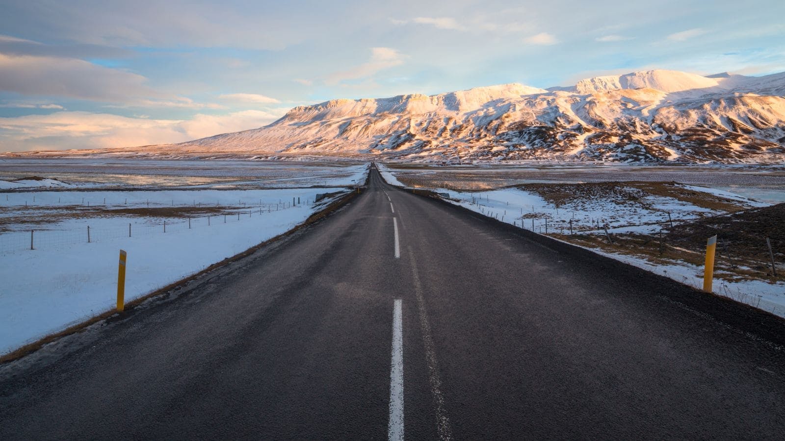 View of the Ring Road in Iceland with snowy mountains in the distance.