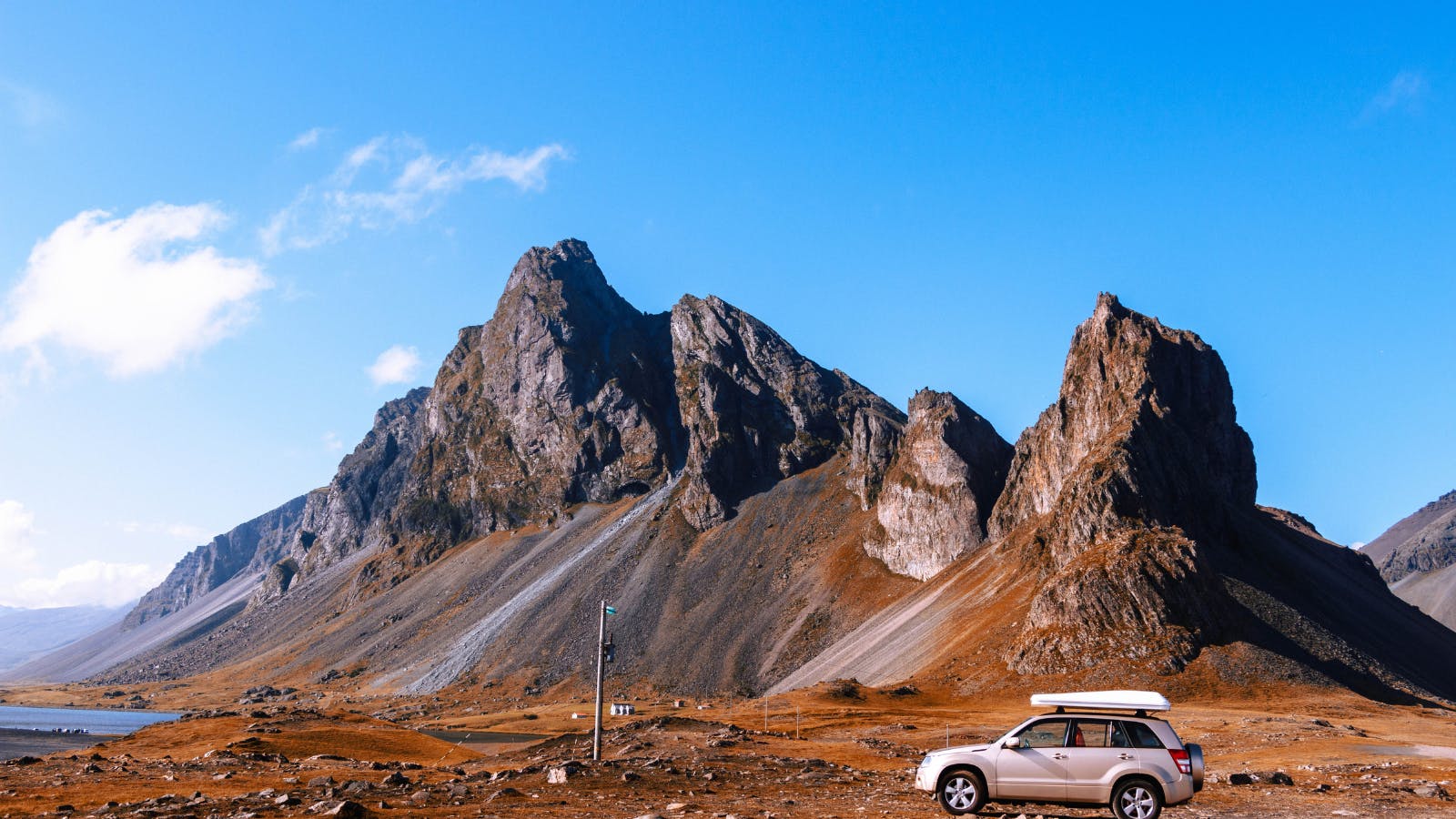 Car parked in front of a mountain in Iceland.