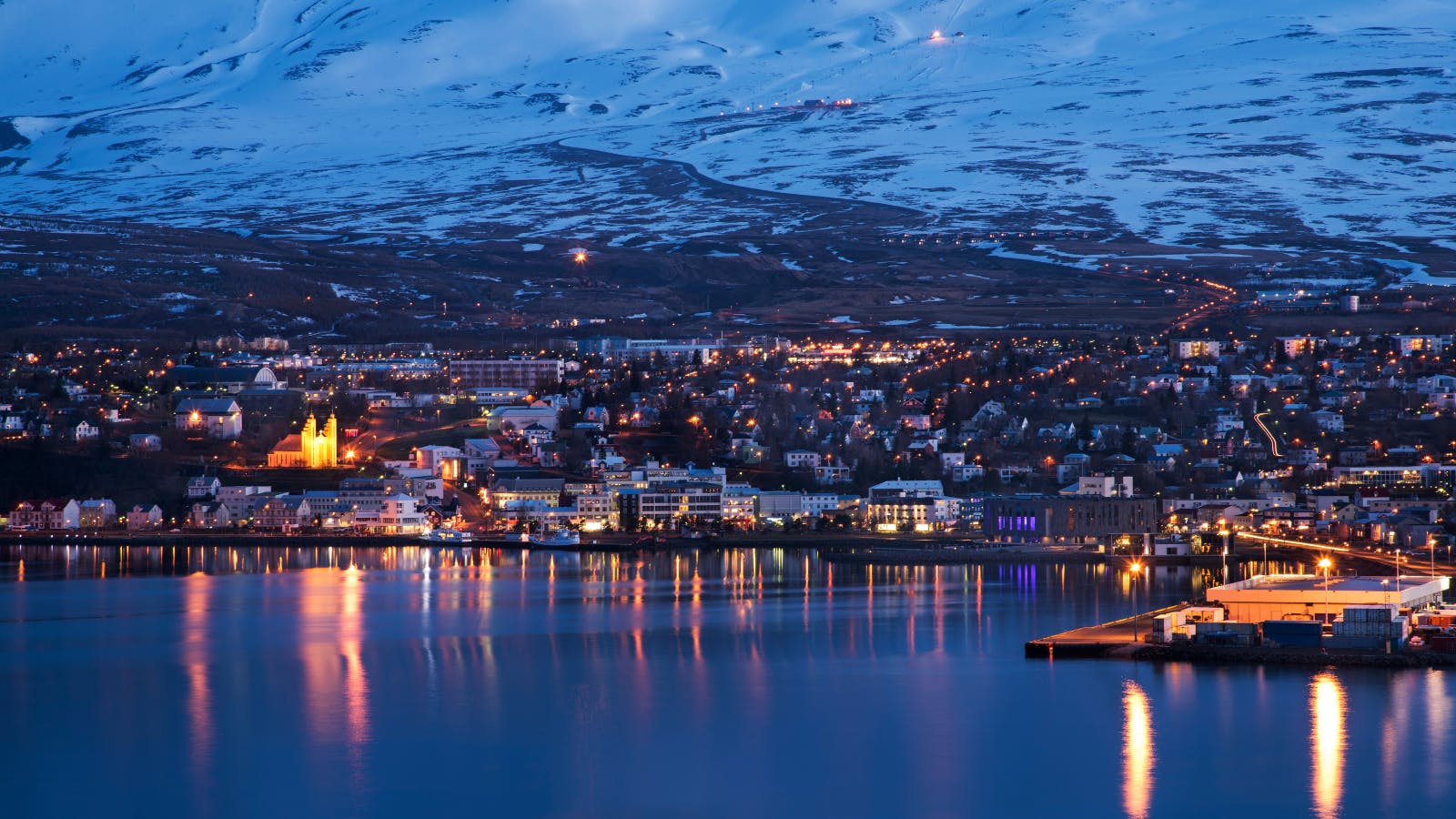 Buildings of Akureyri lit up in the evening.