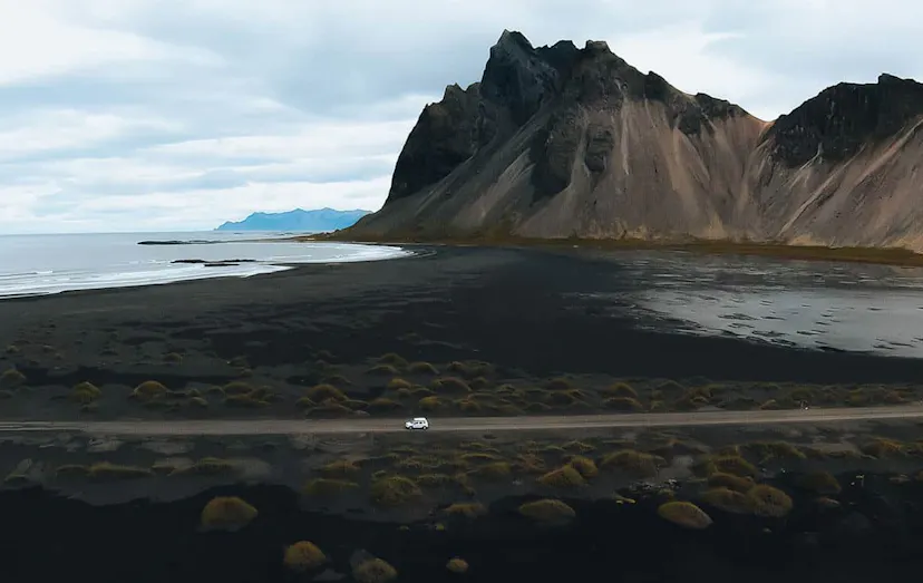 Aerial view of a white car on a mountain road in Iceland