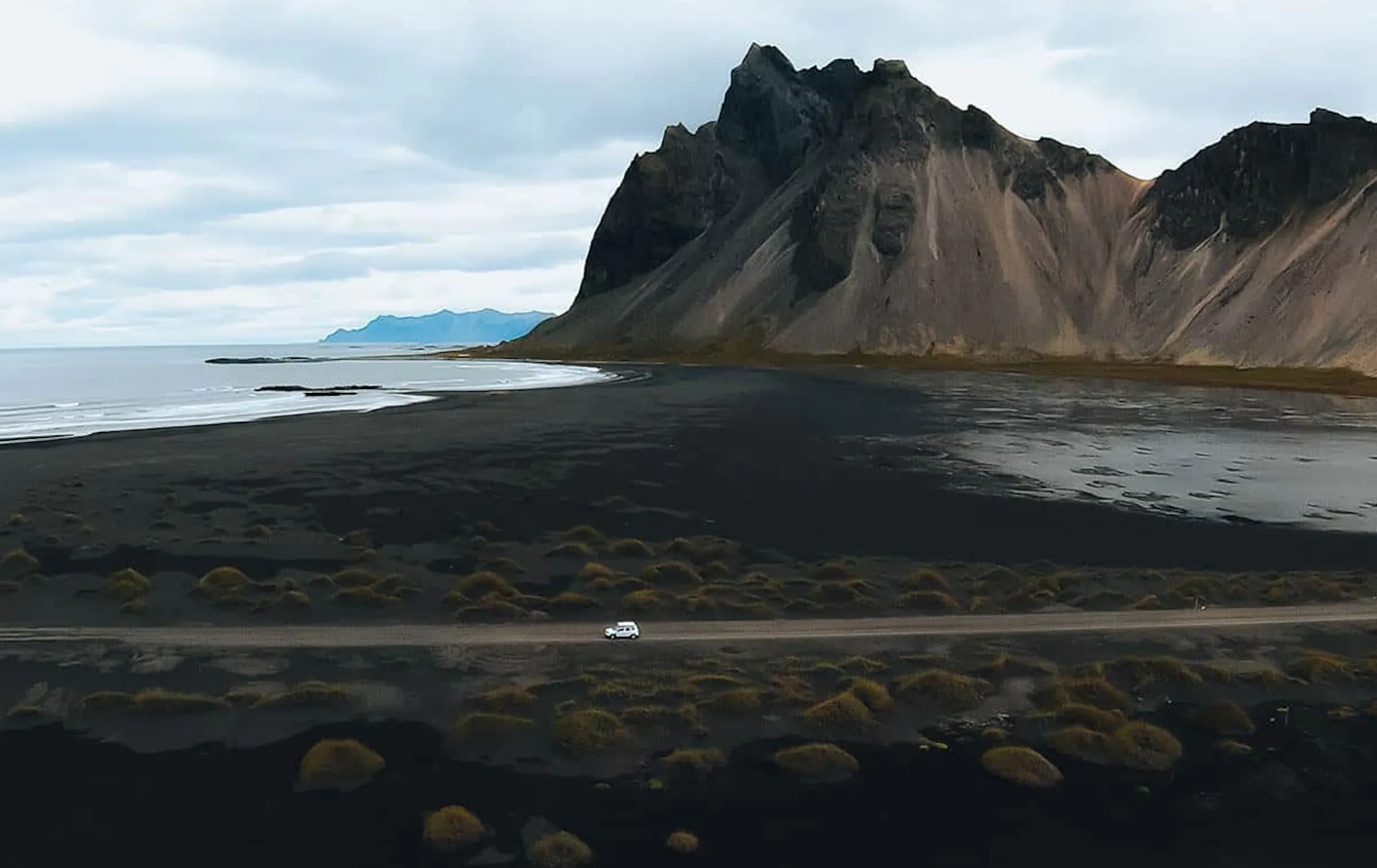 Aerial view of a white car on a mountain road in Iceland
